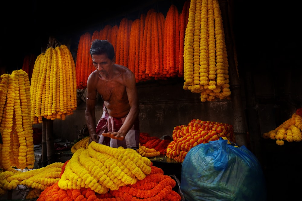 a man standing in front of a pile of corn