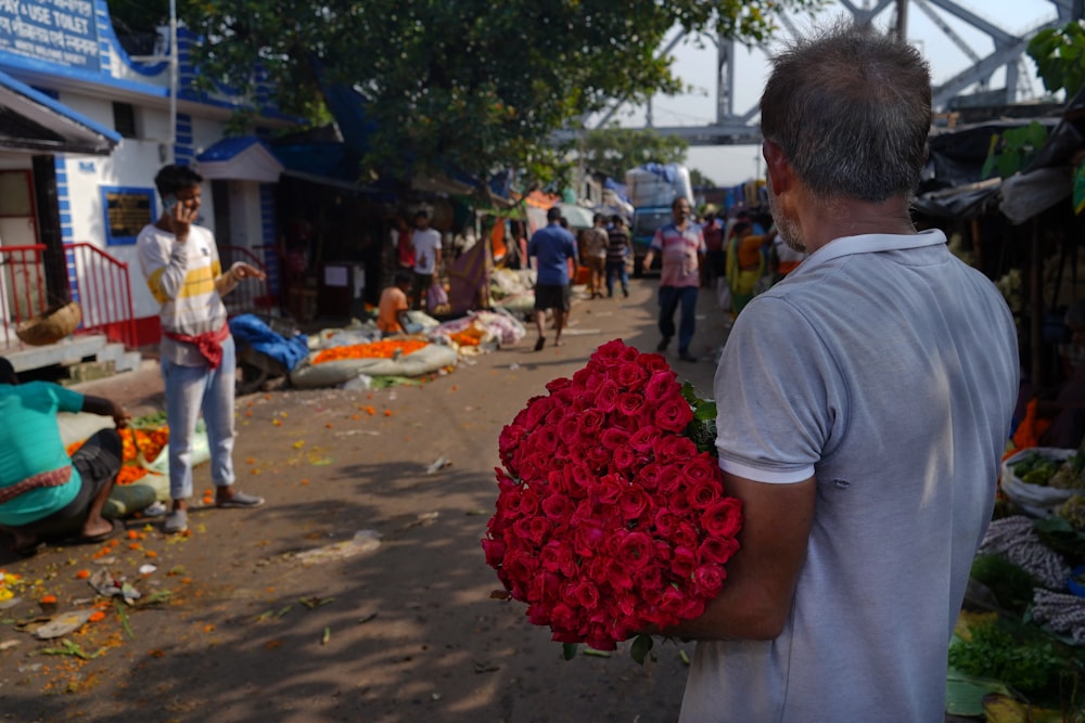 a man holding a bouquet of red roses