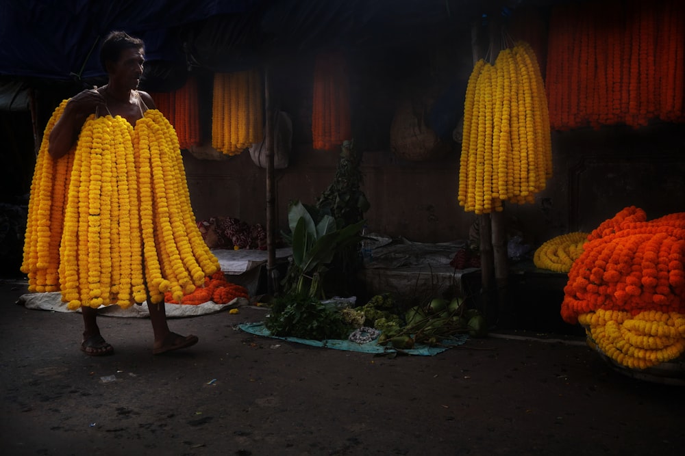 a man standing in front of a bunch of corn