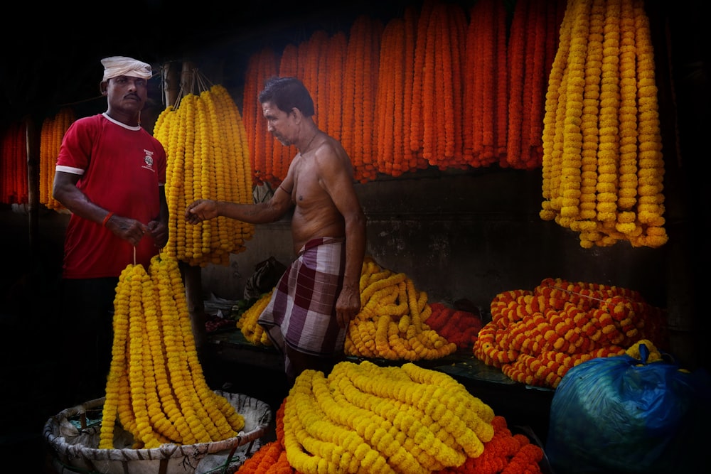 a man standing next to a pile of corn