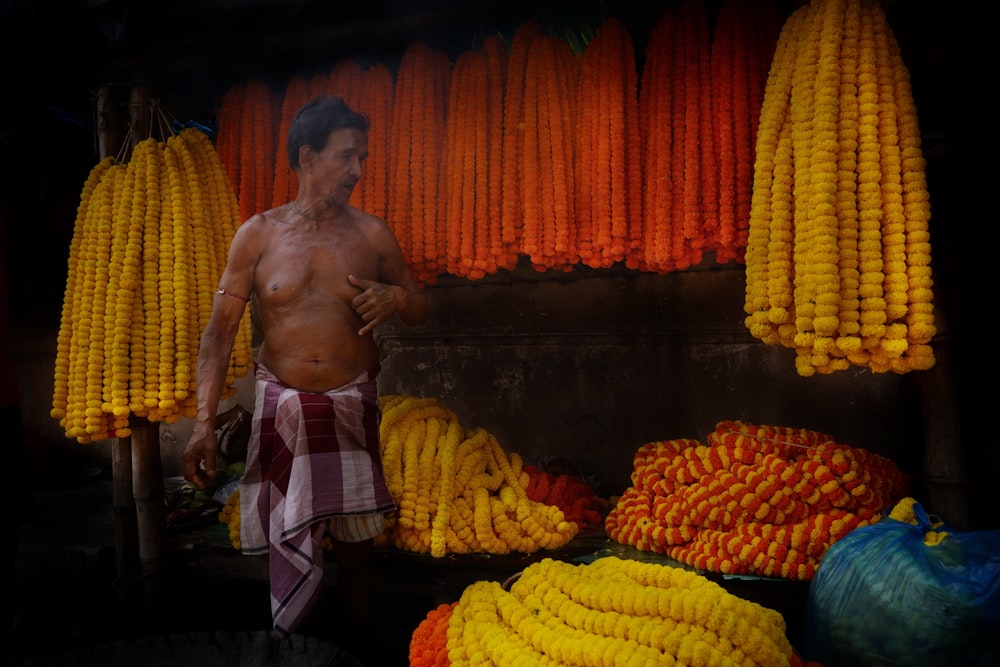 a man standing in front of a display of corn on the cob