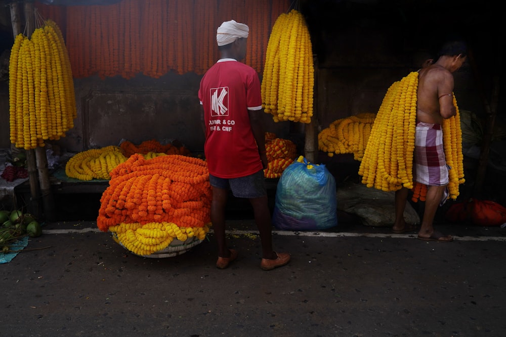 a man standing next to a pile of corn