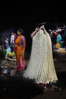 a woman in a sari holding a large bag of flowers