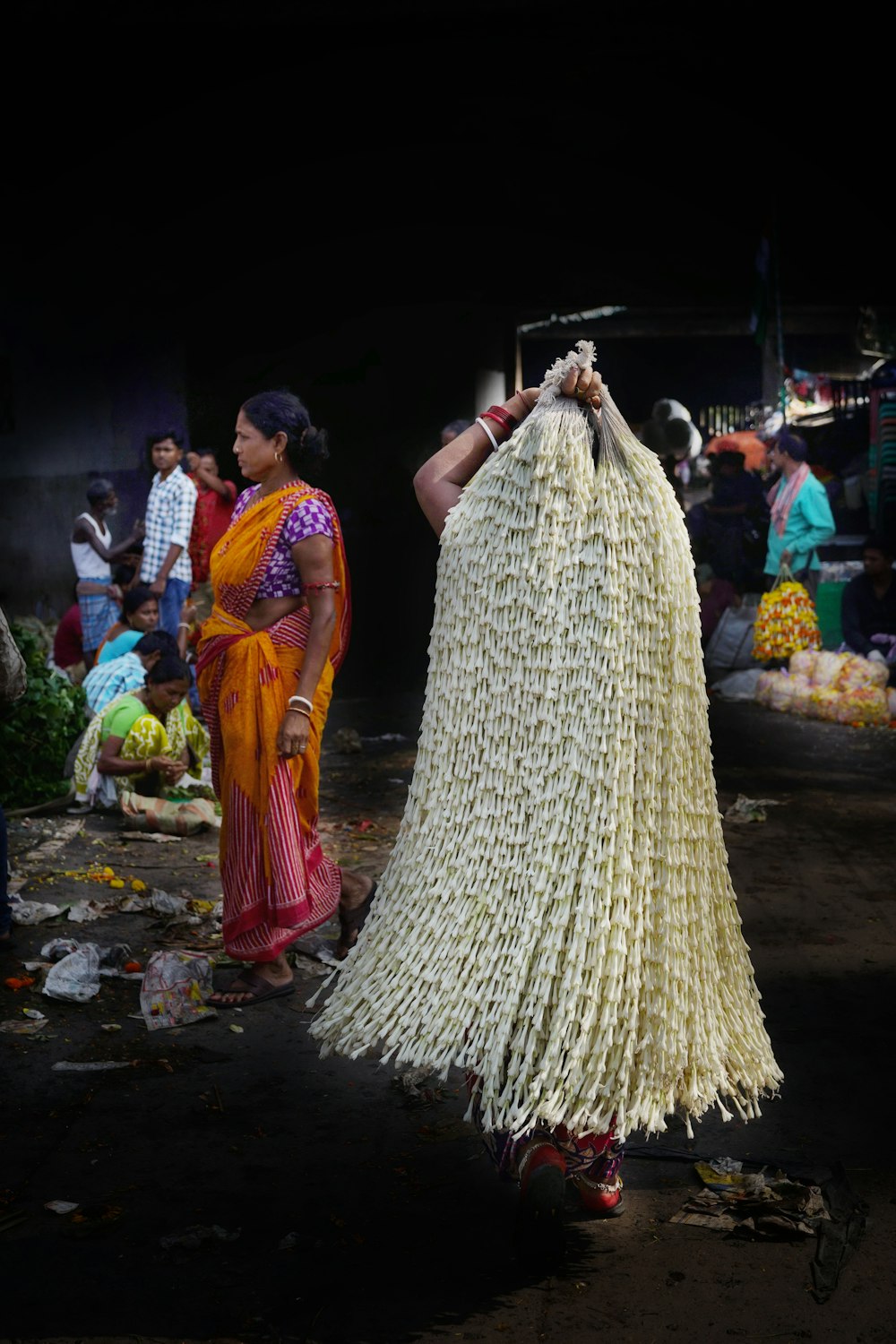 a woman in a sari holding a large bag of flowers