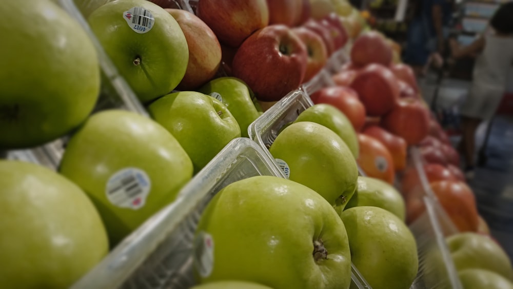 a display of green and red apples in a grocery store