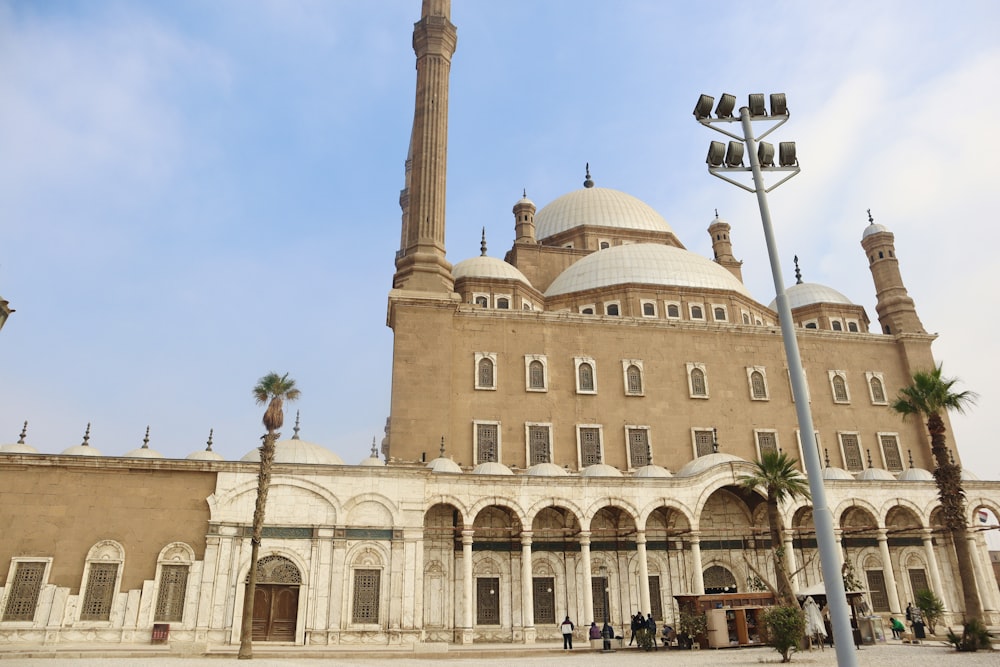 a large building with a tall tower next to a street light