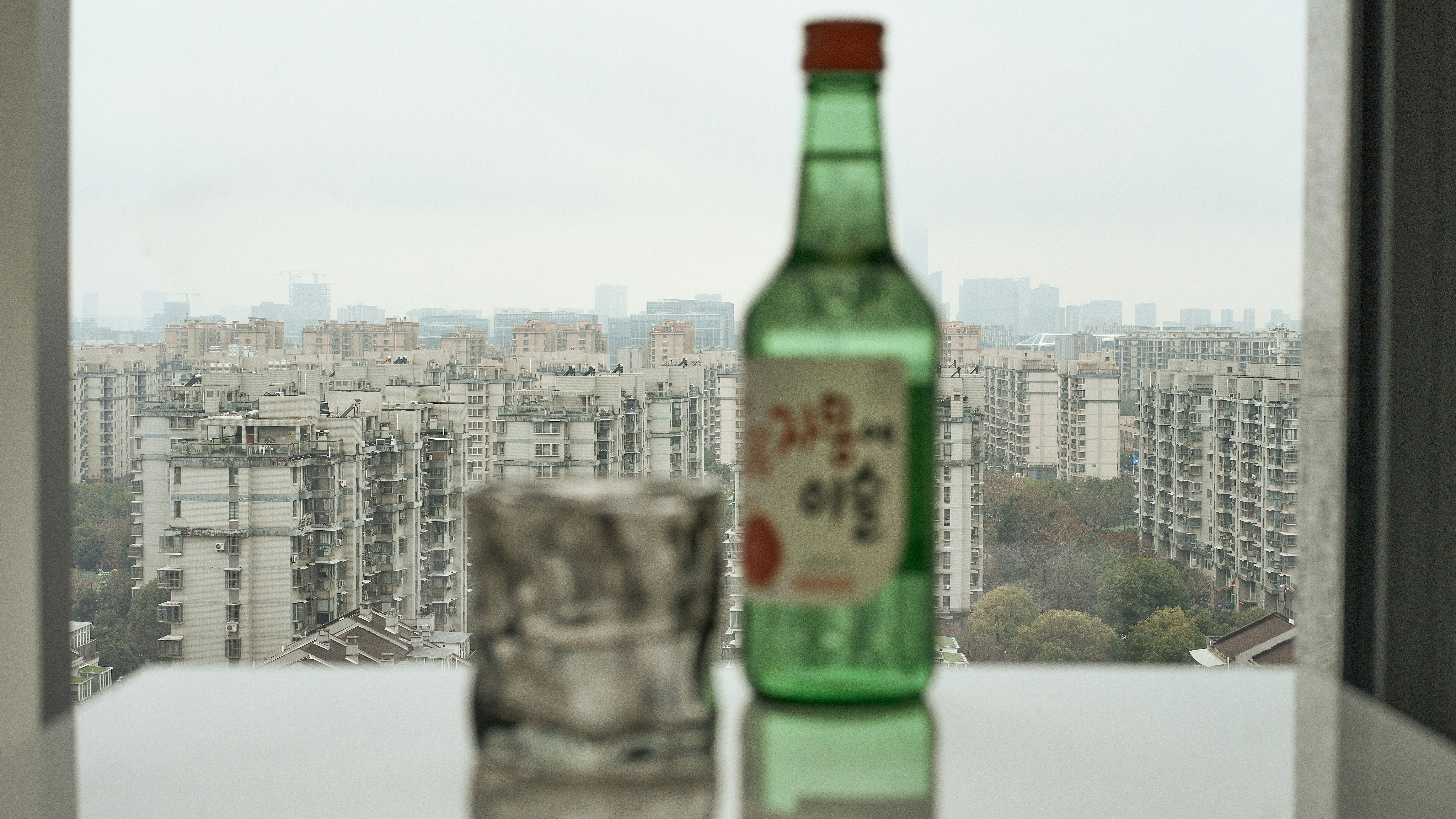 a bottle of beer sitting on top of a window sill