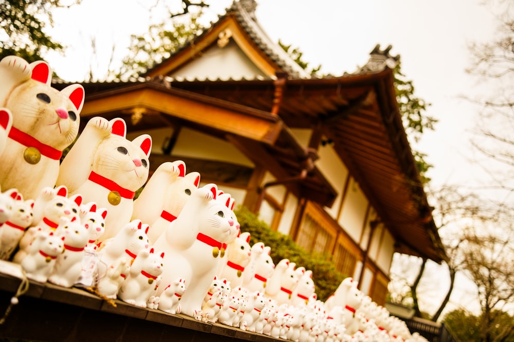 a row of white cat figurines in front of a building