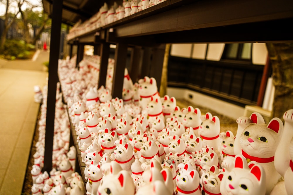 a row of white ceramic cat figurines on display