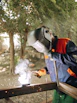 a man welding a piece of metal in a forest