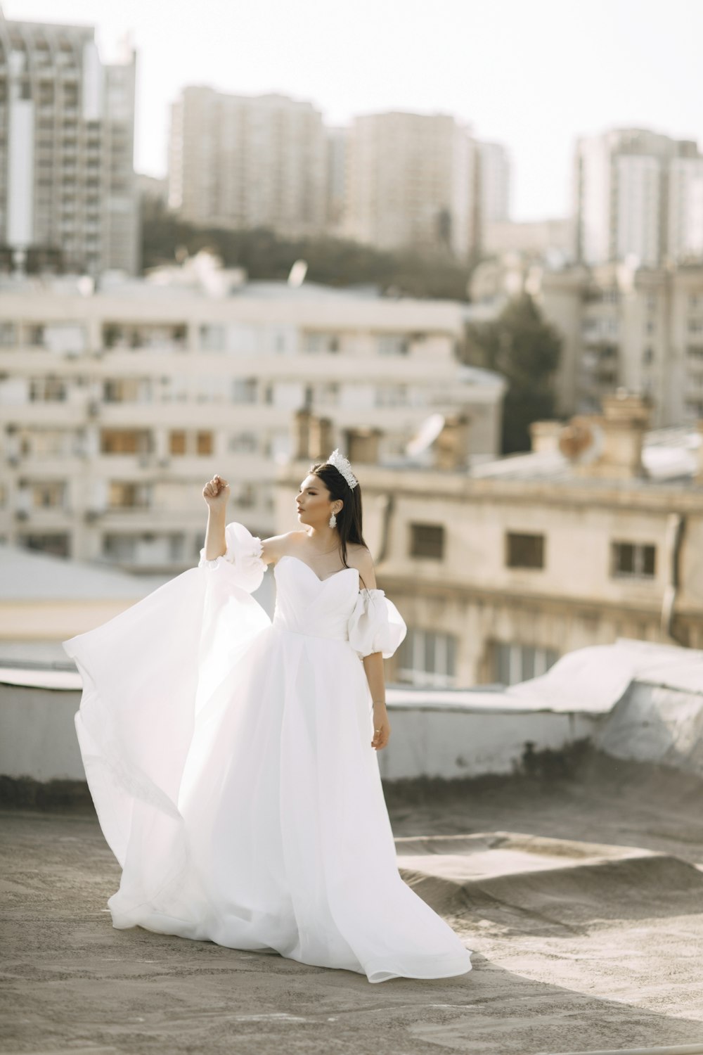 a woman in a white dress standing on a roof