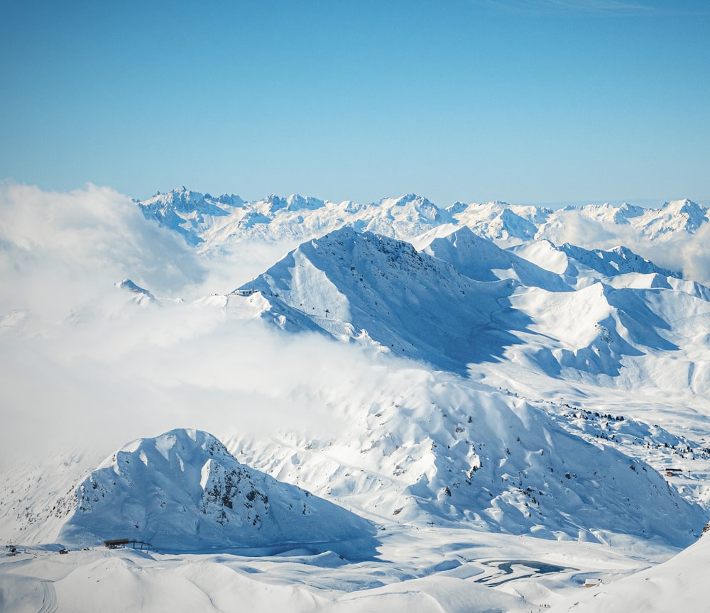 a mountain range covered in snow under a blue sky