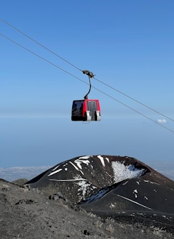 a red and black ski lift going over a mountain