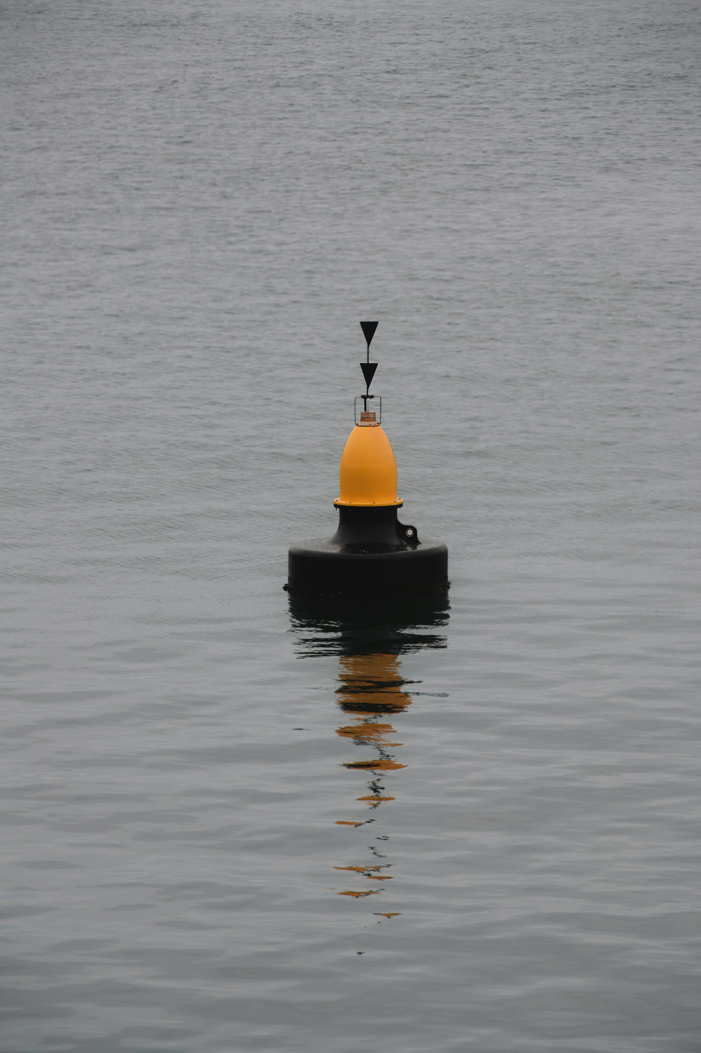 a yellow and black buoy floating on top of a body of water