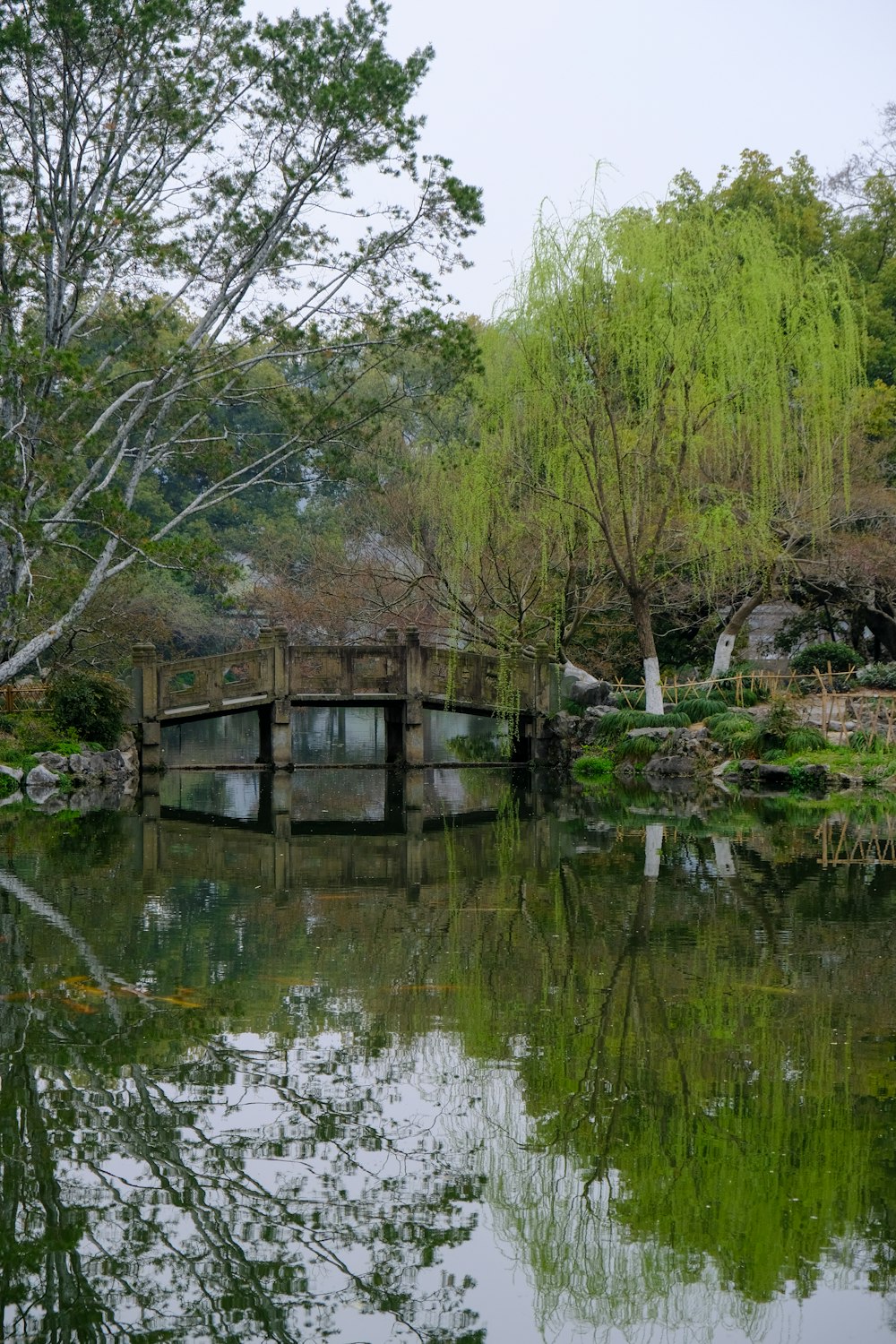 a bridge over a body of water surrounded by trees