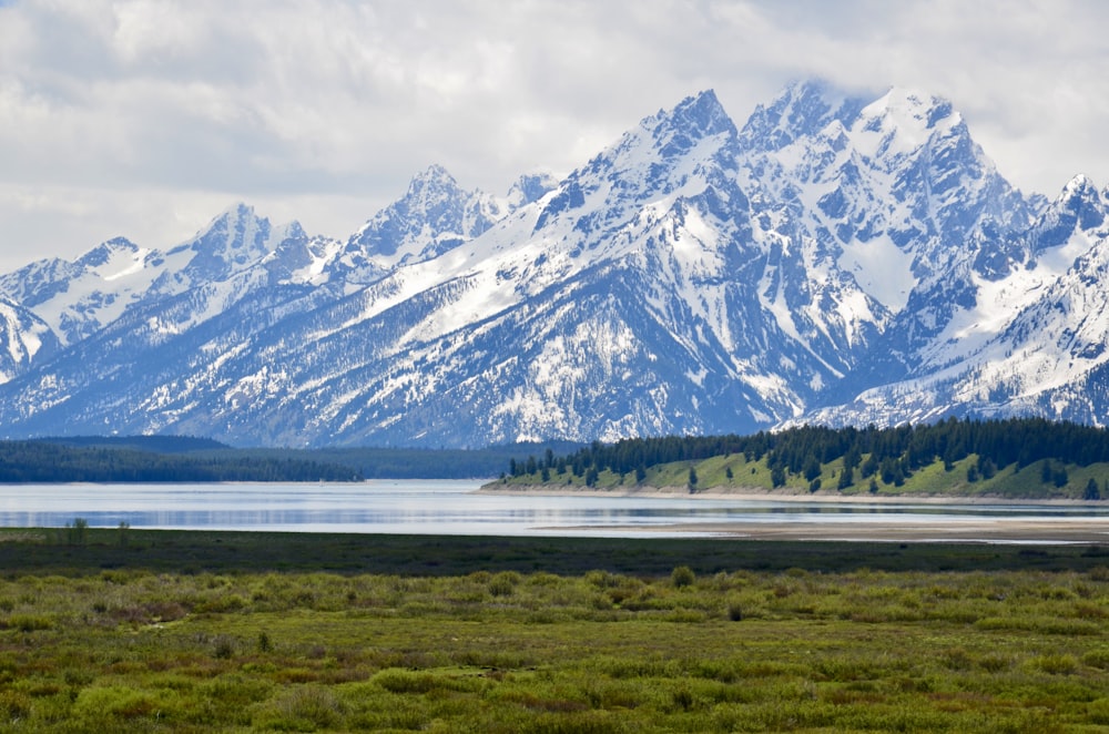 a mountain range with a lake in the foreground