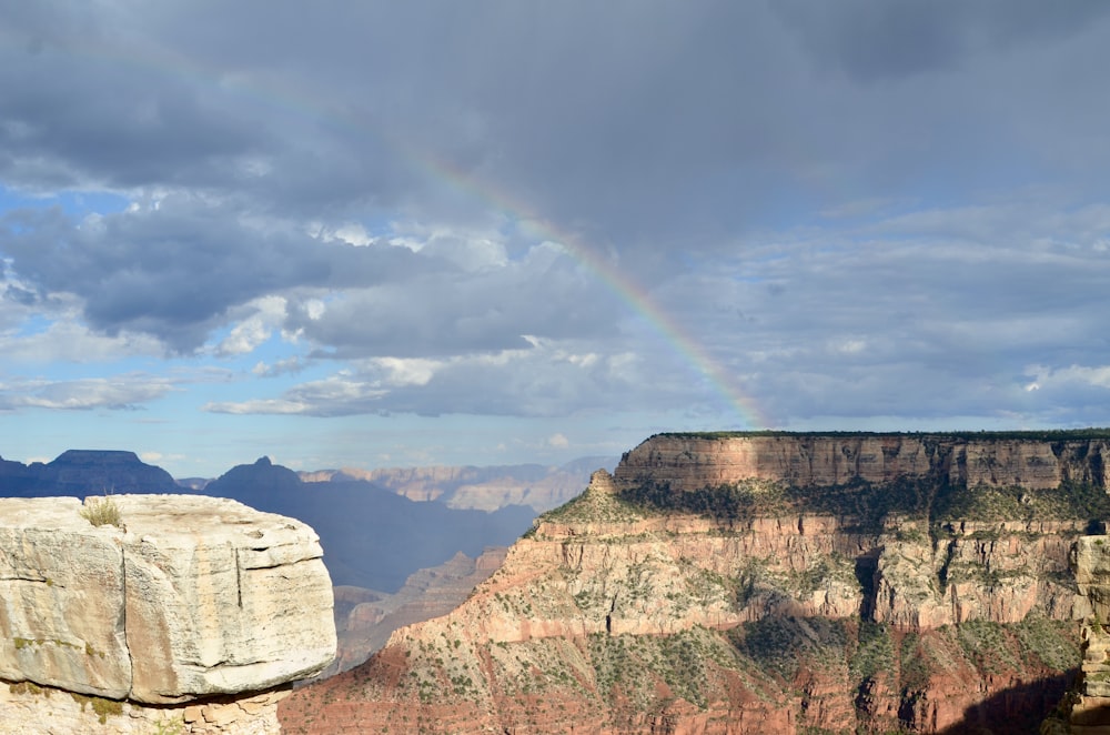 a rainbow in the sky over a canyon