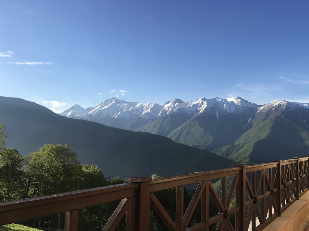 a wooden bridge with mountains in the background