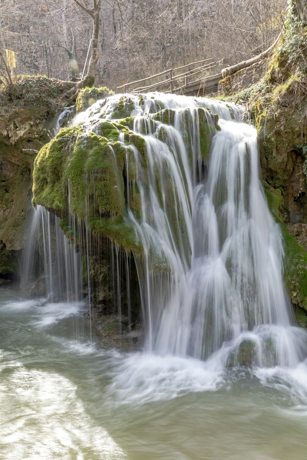 a waterfall with moss growing on the rocks