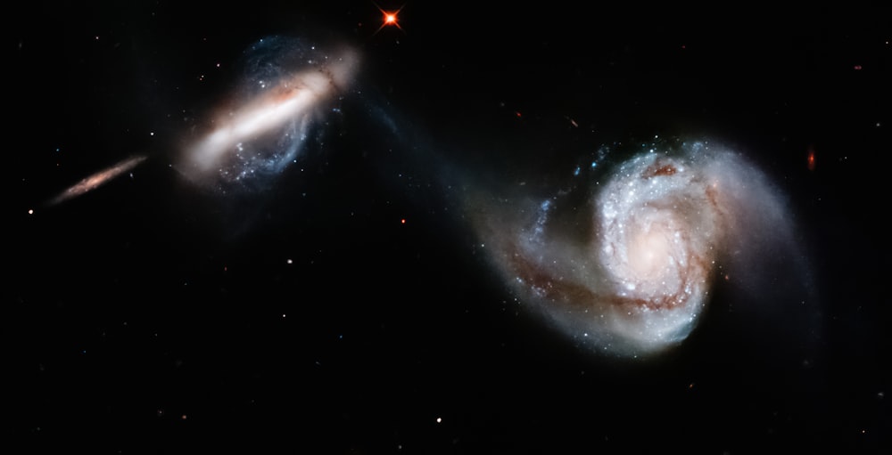 two spiral galaxy like objects in the dark sky