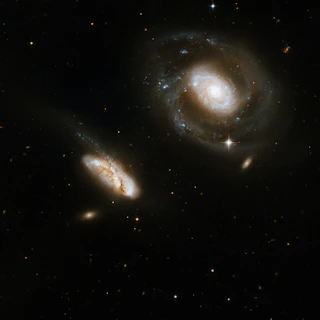 two spiral galaxy like objects in the dark sky