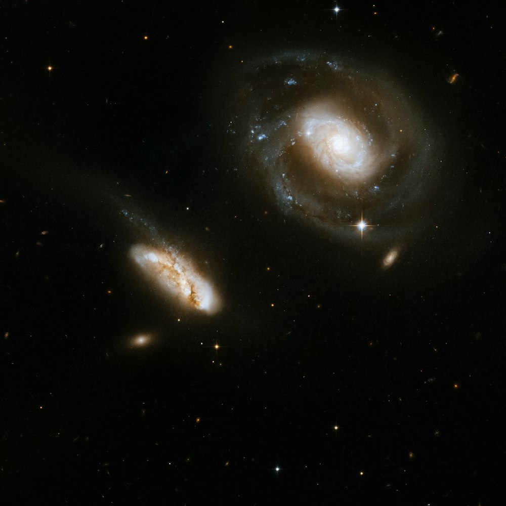 two spiral galaxy like objects in the dark sky