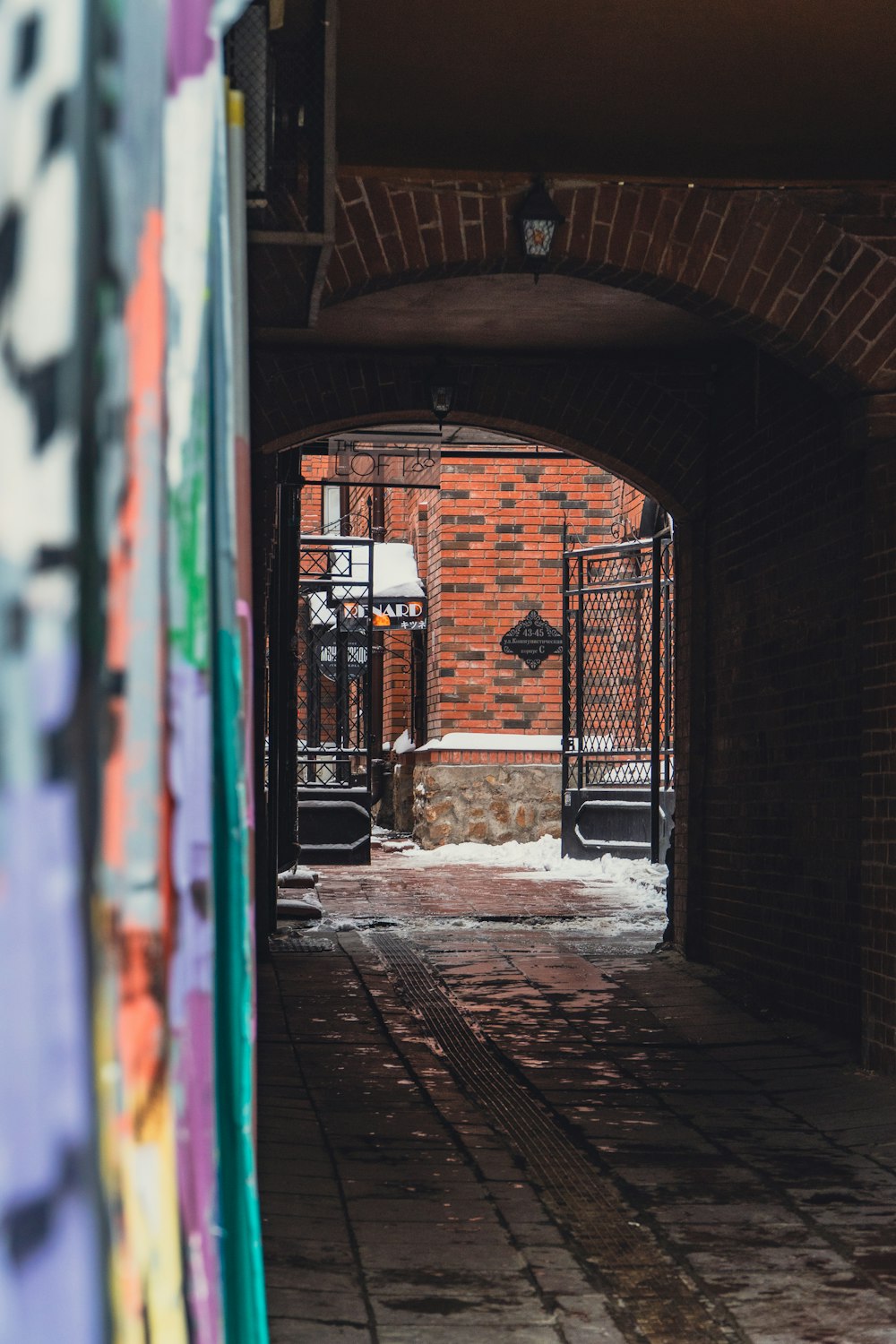 a brick building with a gate and snow on the ground