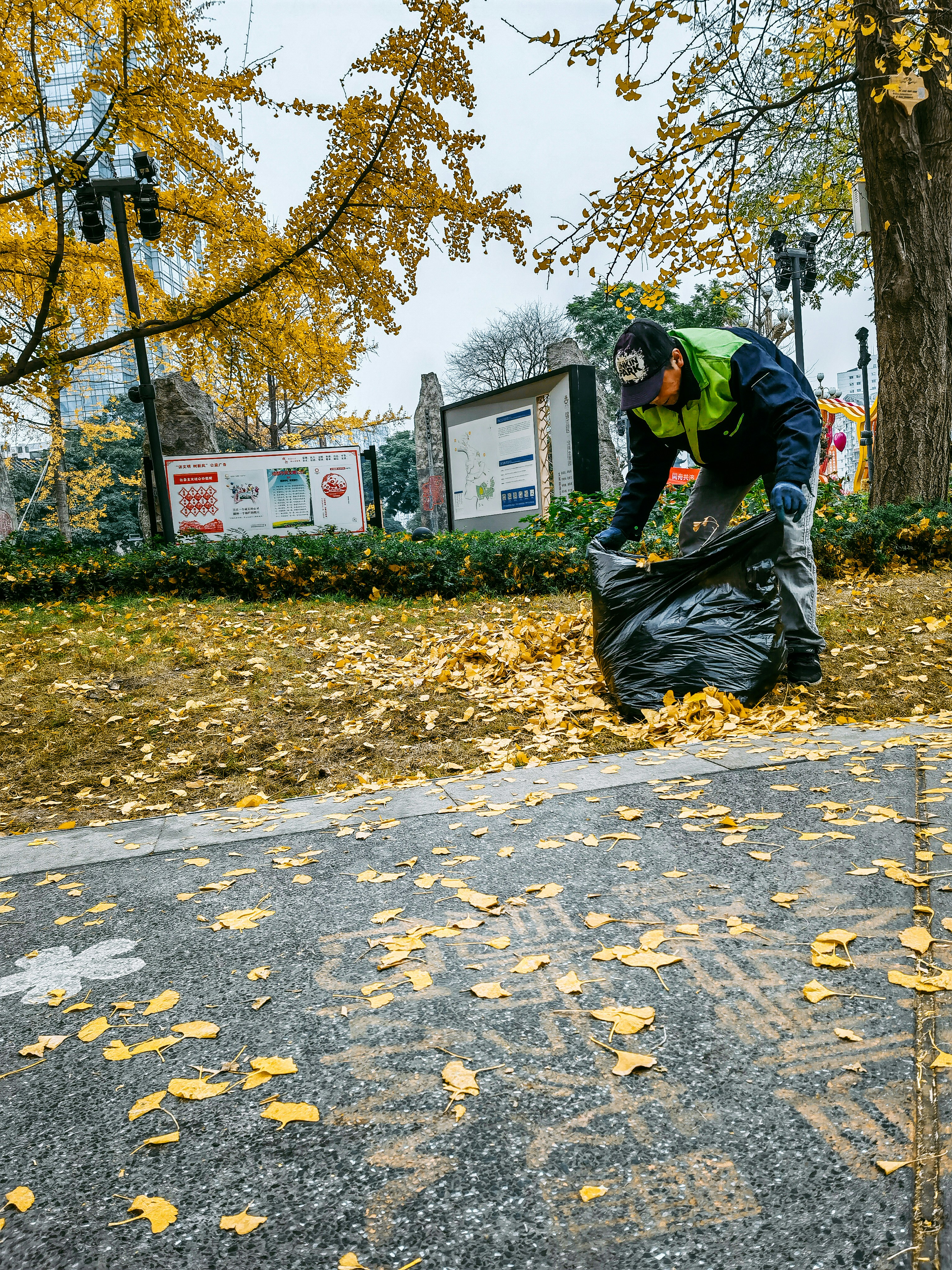 a man is picking up leaves from the ground