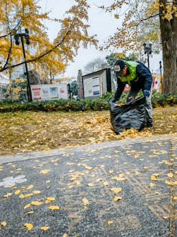 a man is picking up leaves from the ground