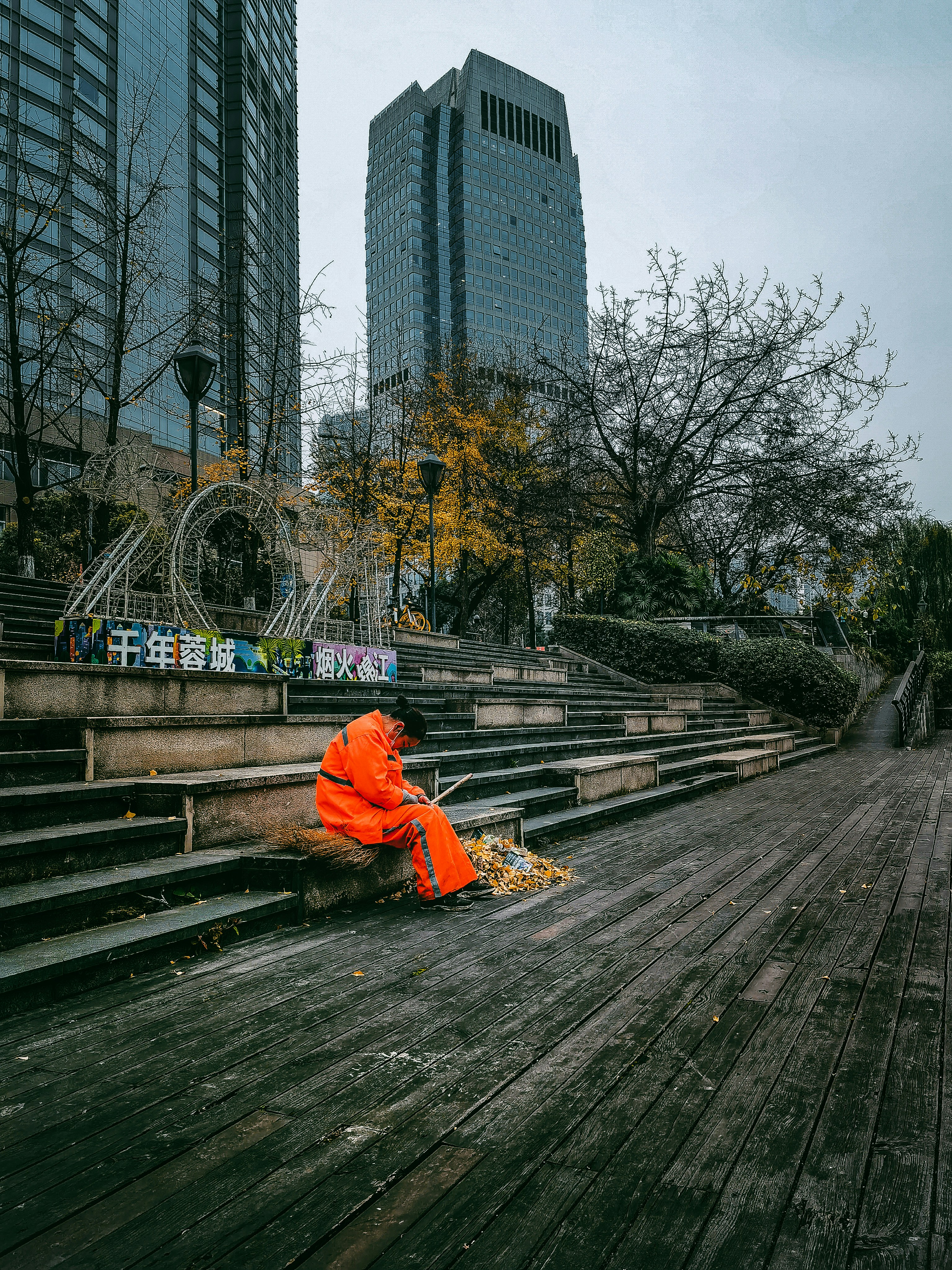a person in an orange jacket sitting on some steps