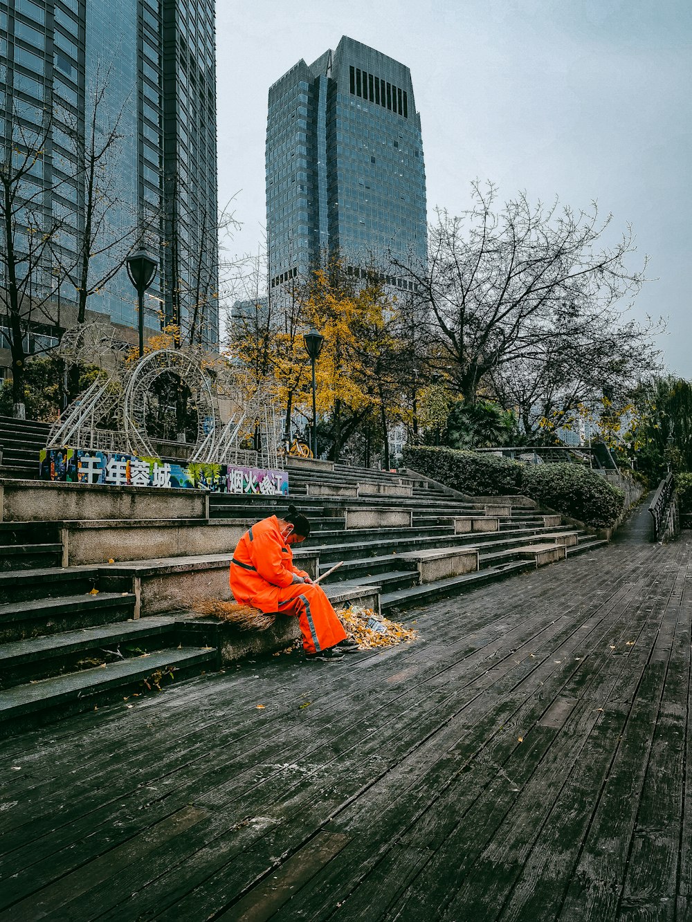 a person in an orange jacket sitting on some steps