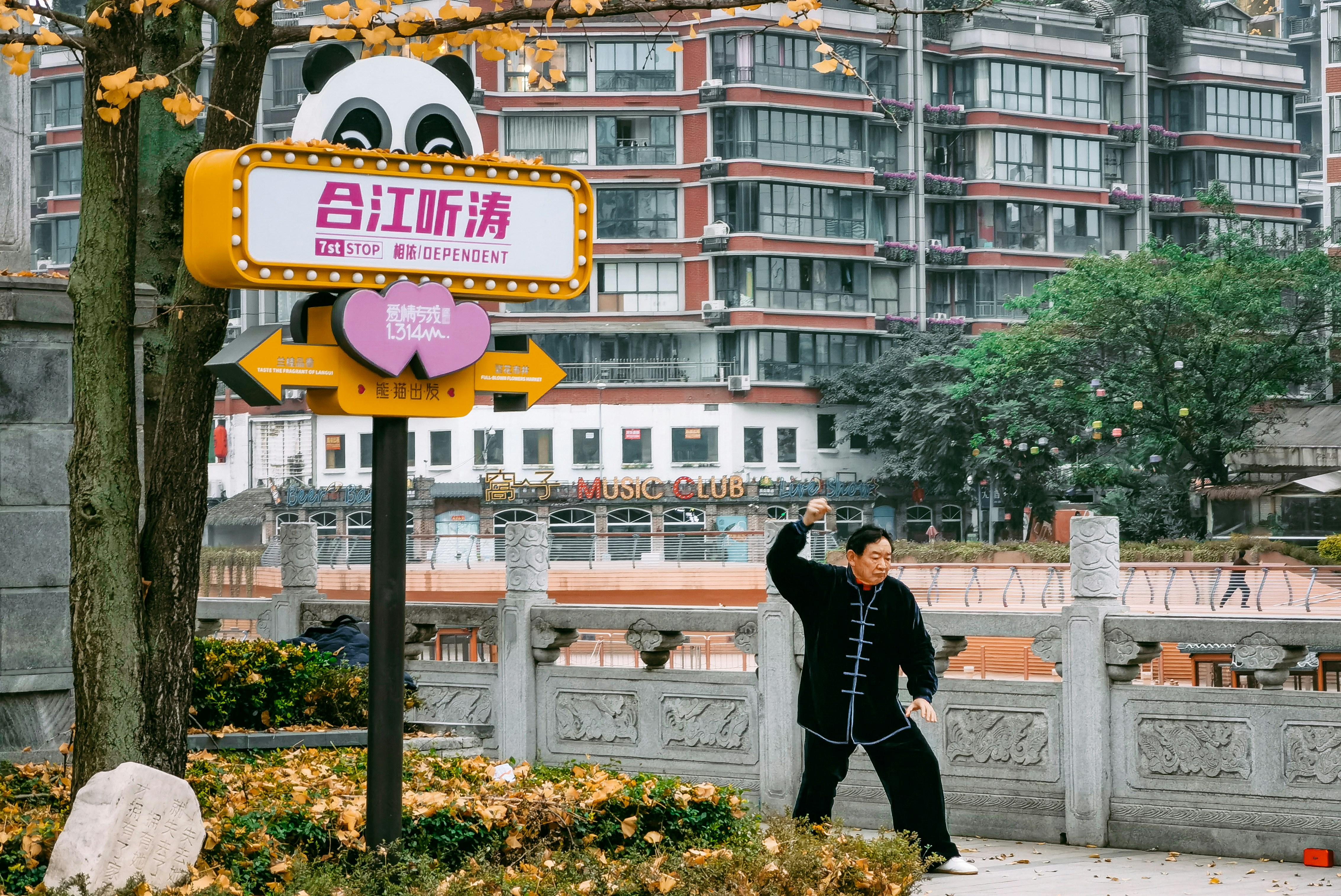 A man taking a picture of a sign in front of a building photo – Free ...
