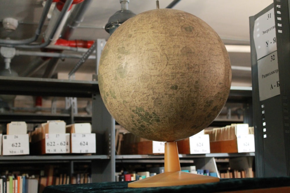 un grande globo di legno su un supporto di legno in una biblioteca