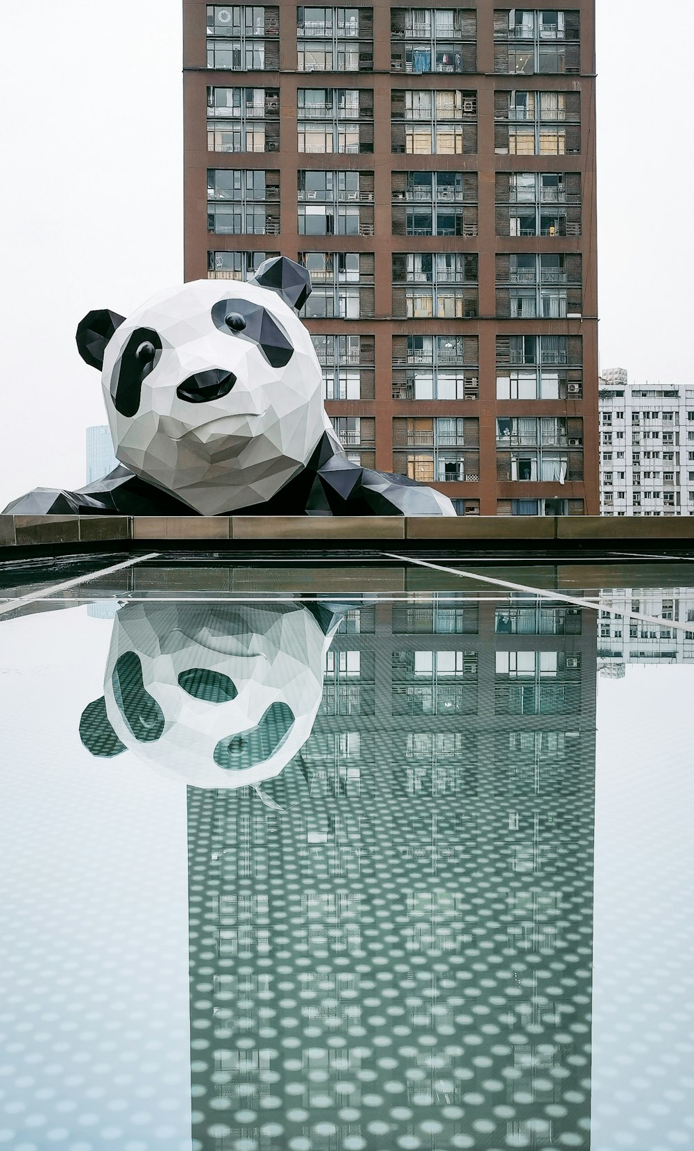 a giant panda bear sitting on top of a pool