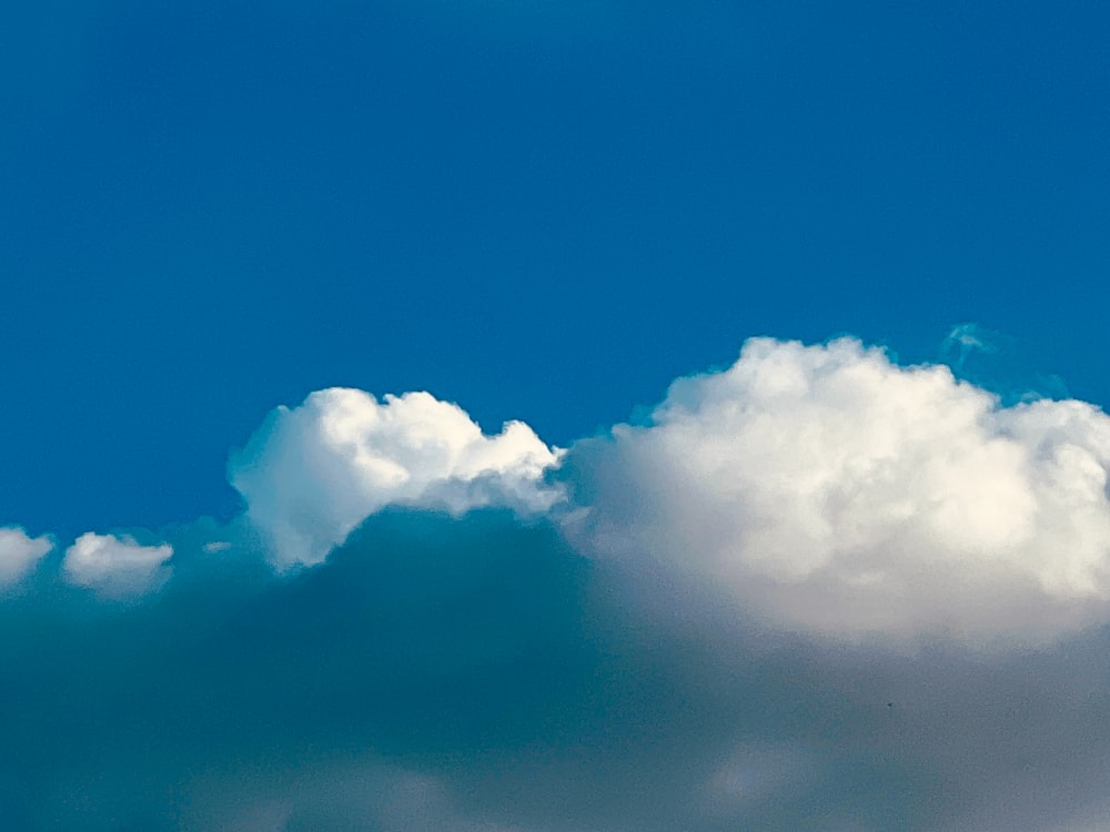 a plane flying through a cloud filled sky