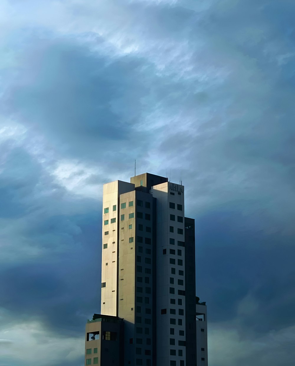 a very tall building sitting under a cloudy sky