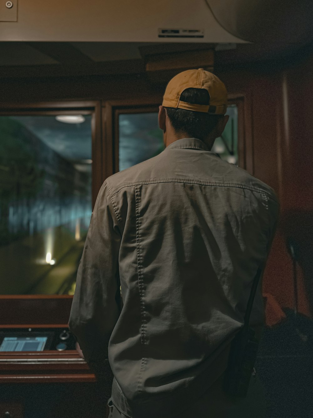 a man standing in front of a window looking out the window