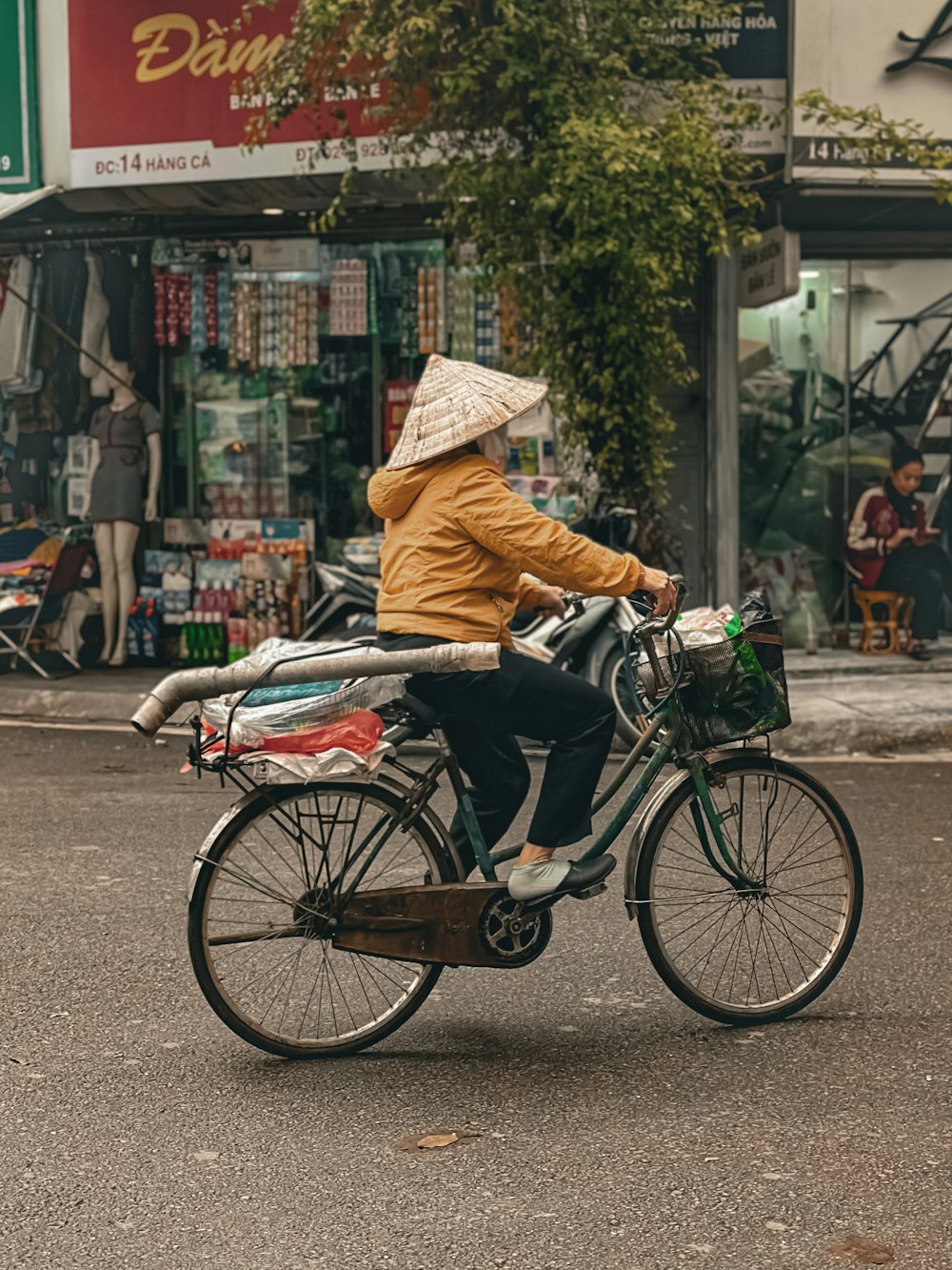 a woman riding a bike down a street