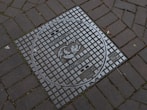 a manhole cover on a brick sidewalk