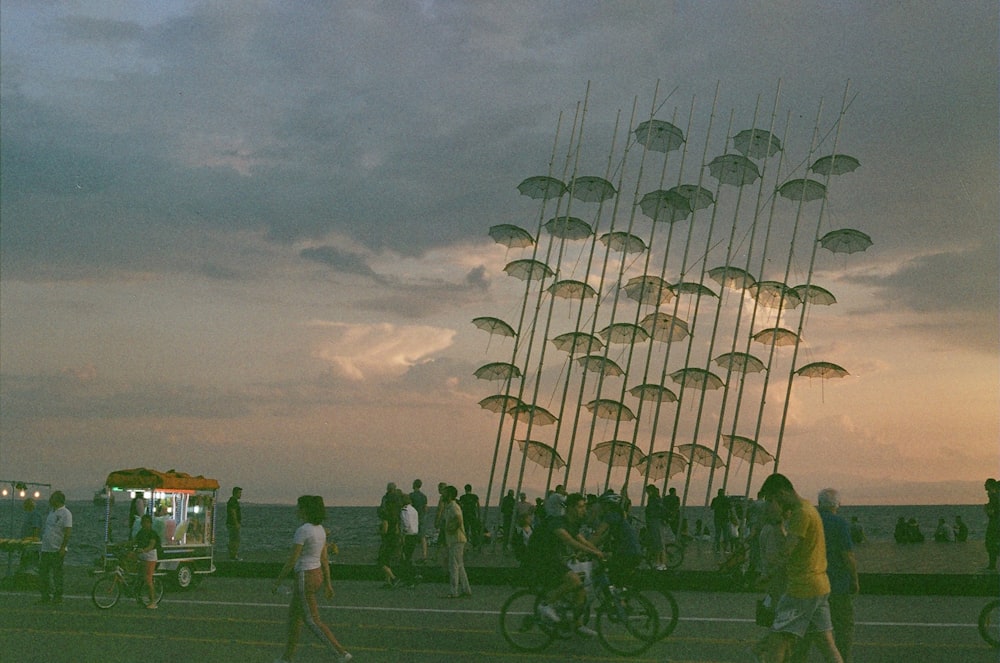 a group of people riding bikes next to a tall sculpture