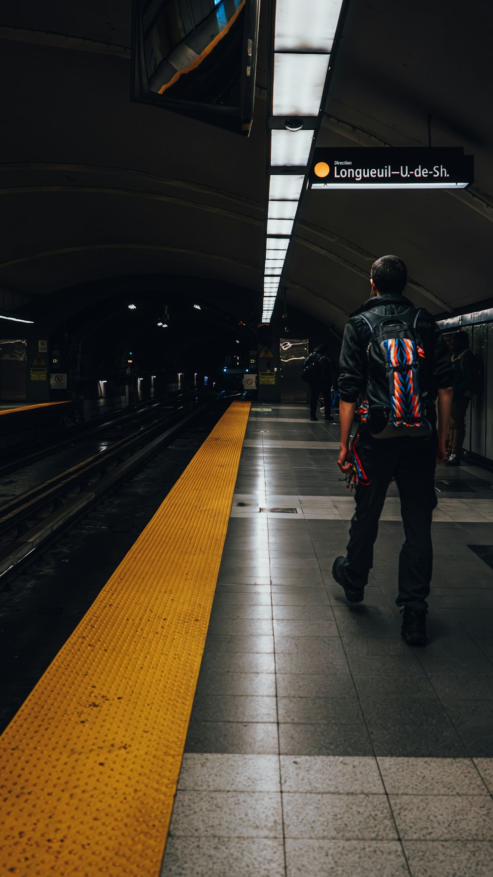 a man walking down a train station platform