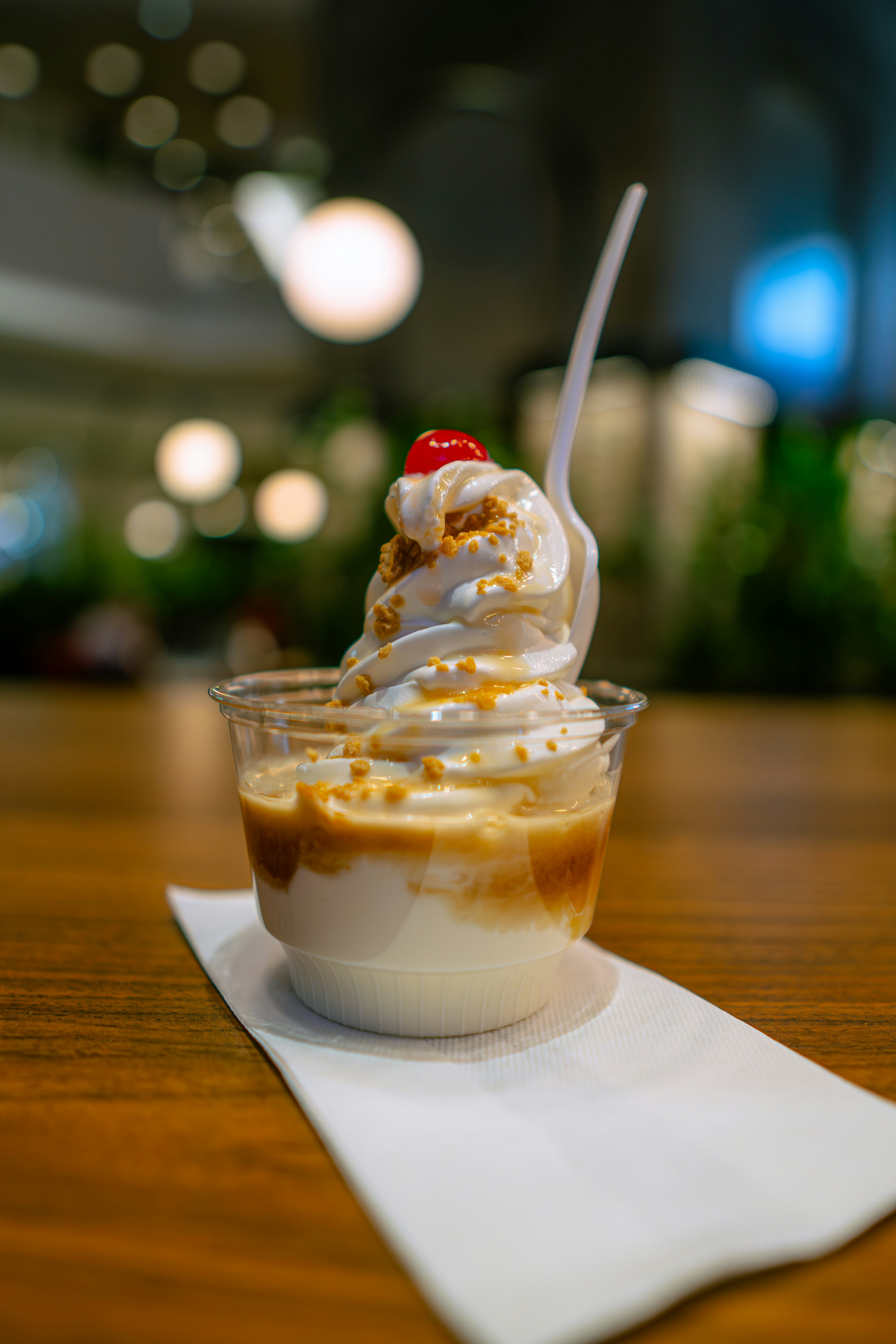 ein Becher Eis mit einer Kirsche oben drauf