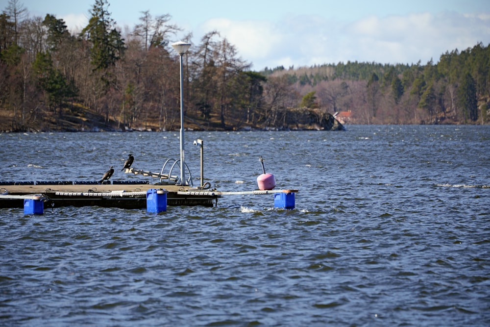 a boat sitting on top of a lake next to a dock