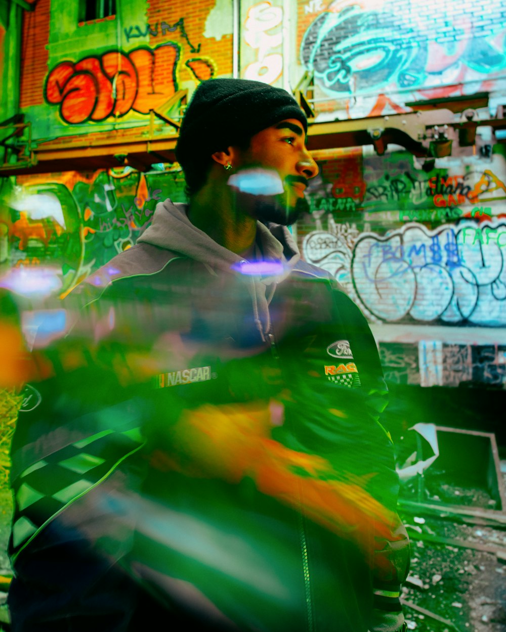 a man standing in front of a building covered in graffiti