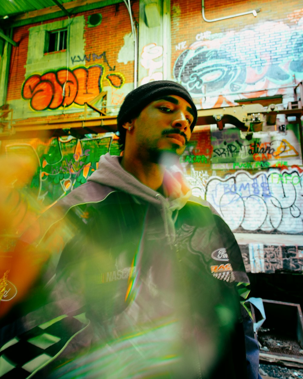 a man standing in front of a building covered in graffiti