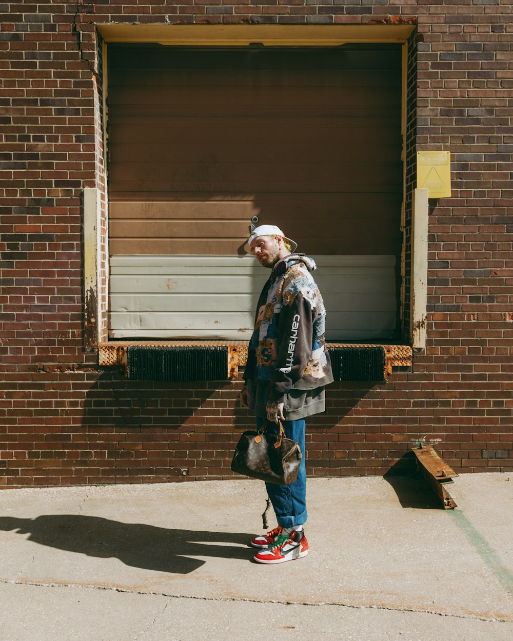 a man standing in front of a brick building