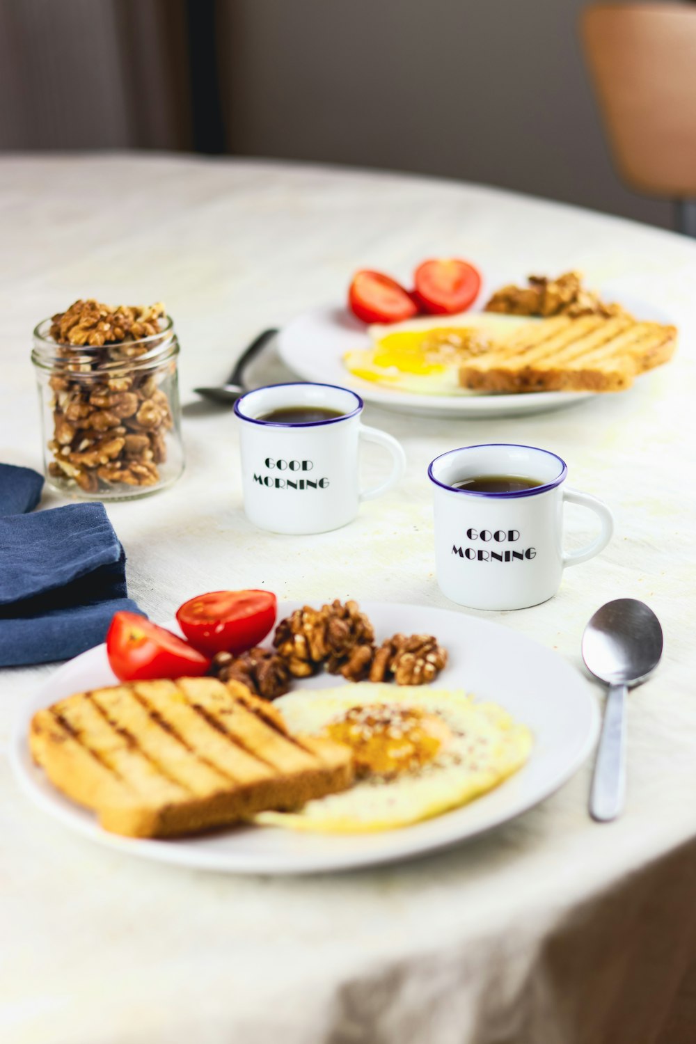 a table topped with plates of food and cups of coffee