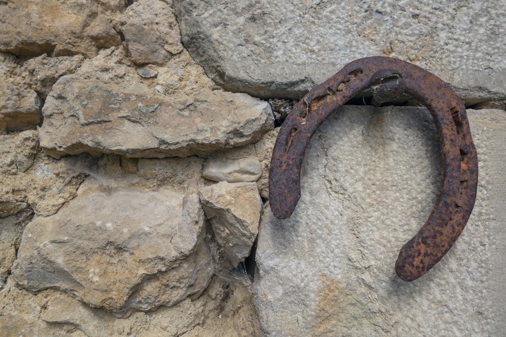 a rusted horseshoe hanging on a stone wall