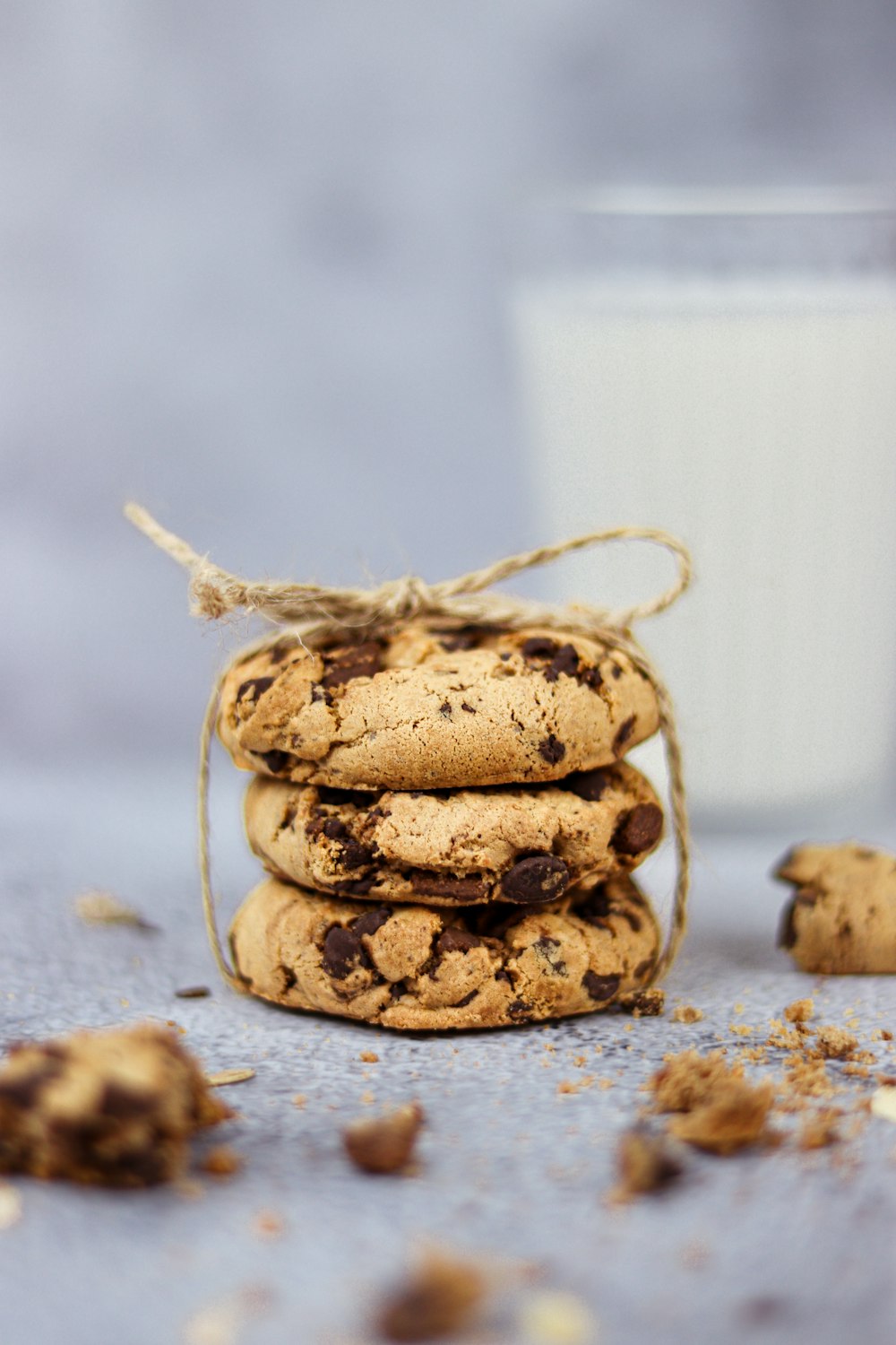 a stack of chocolate chip cookies next to a glass of milk