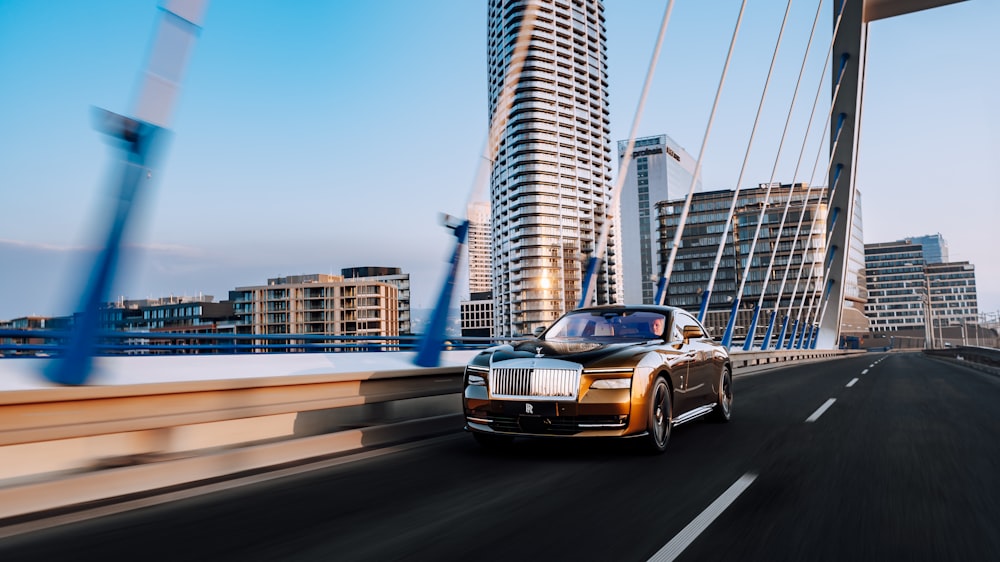 a car driving on a bridge with tall buildings in the background